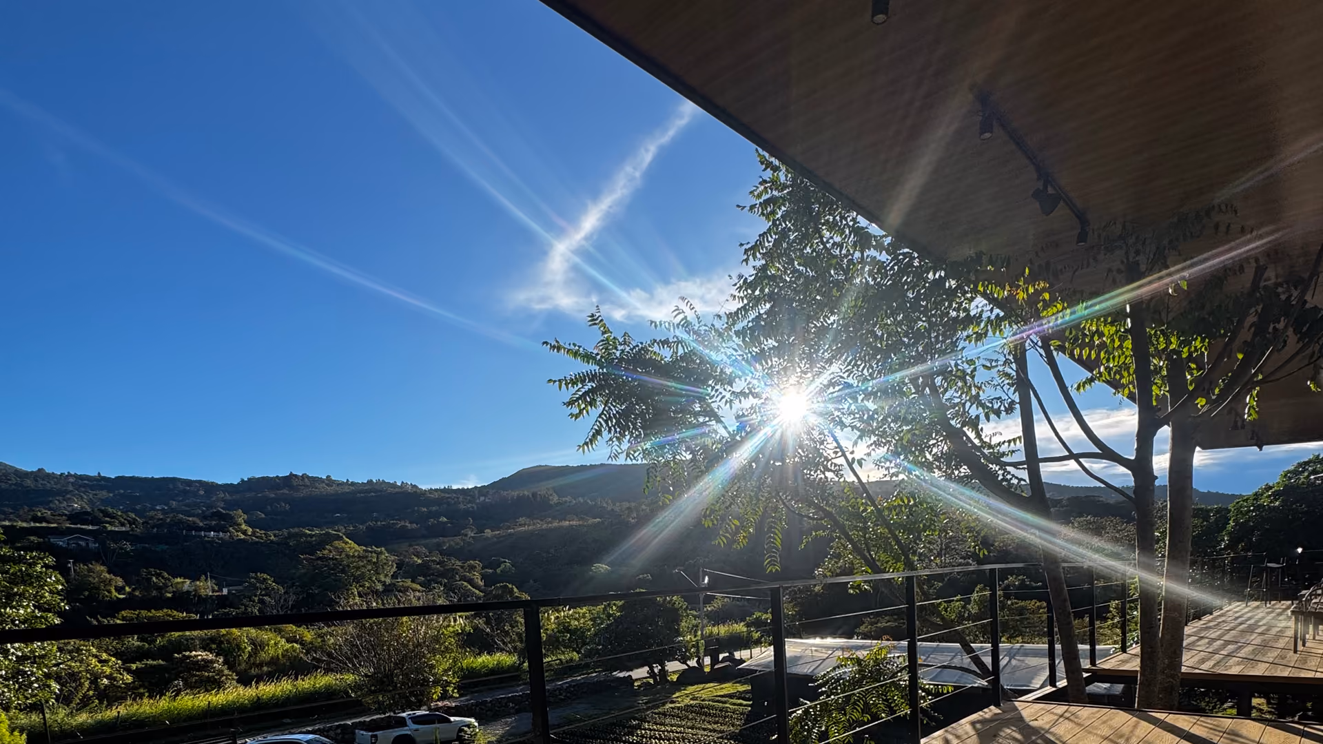Sol de la tarde entre los árboles desde la terraza, con las montañas de Boquete al fondo